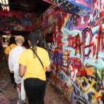 Students walk through the NC State Free Expression tunnel, a tunnel with multicolored graffiti.
