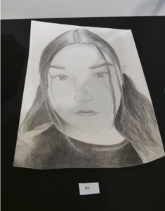 A pencil drawn photo of a girl with long hair.