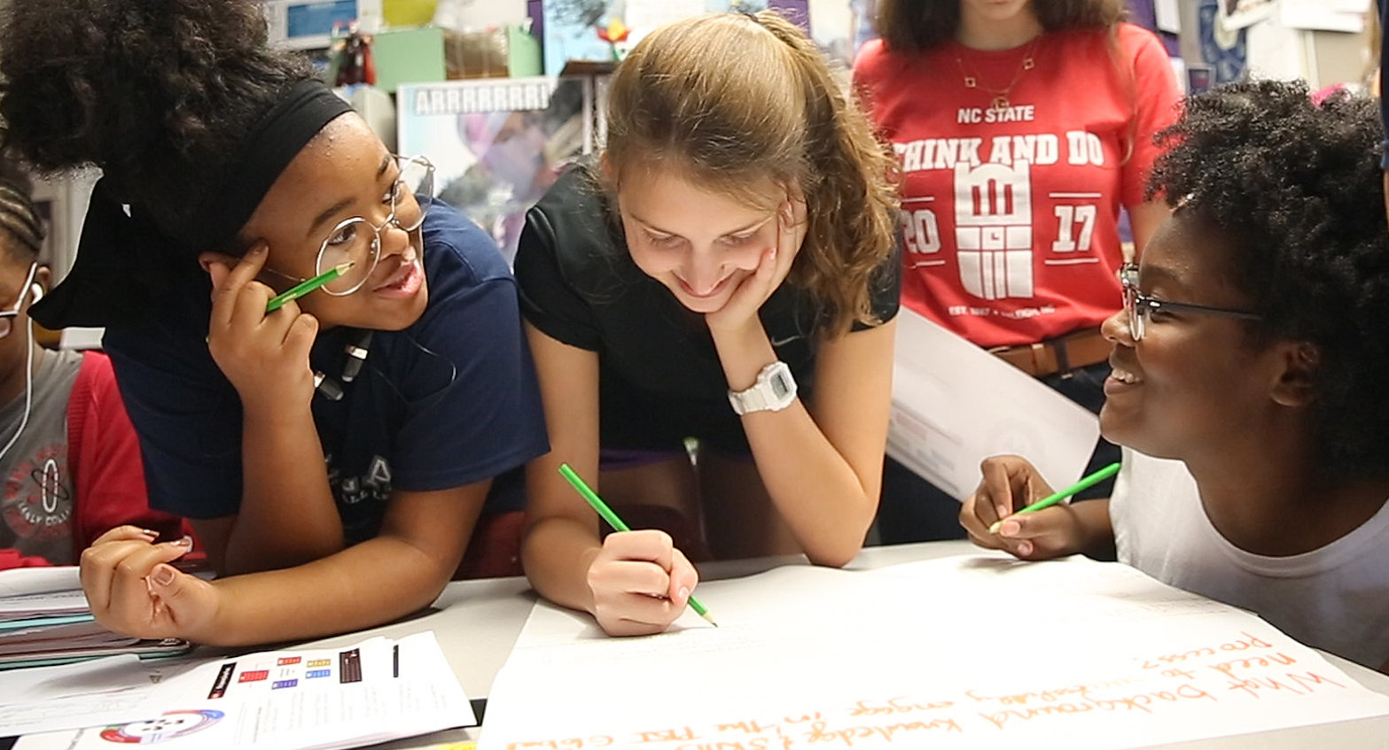 3 students working together on a poster