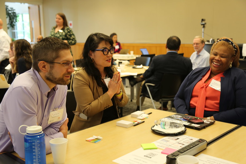 A table of people talk and interact