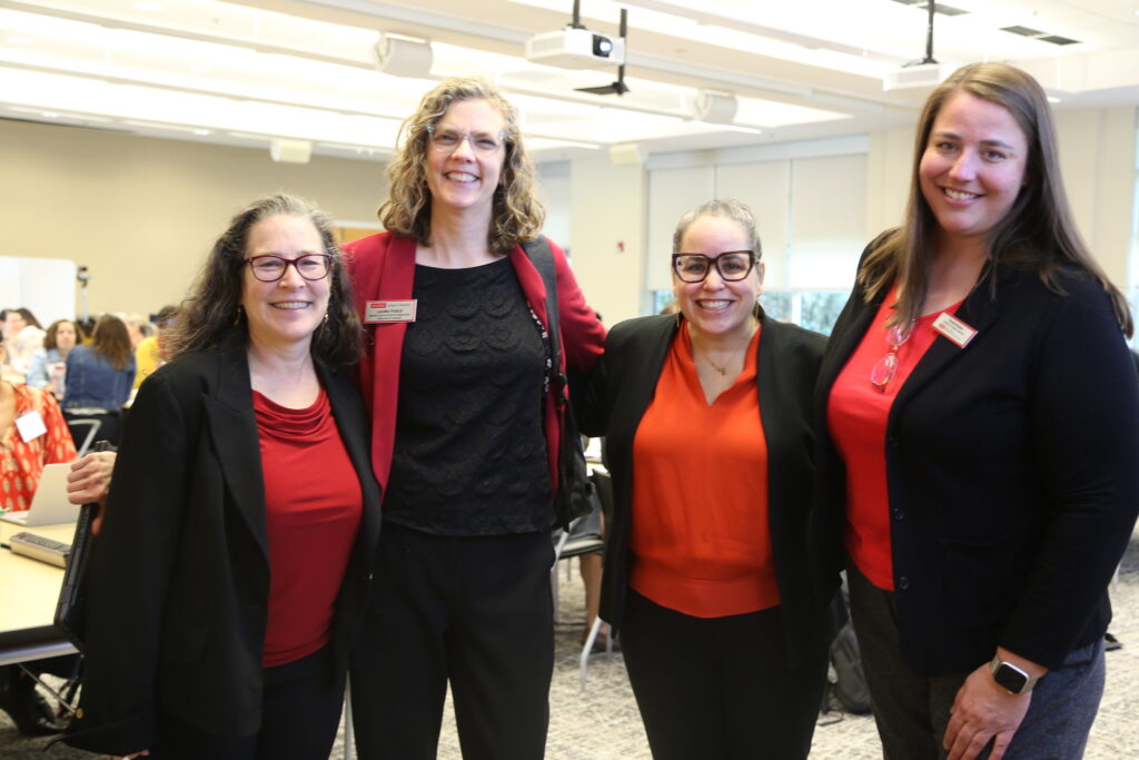 Four women stand in a line posing for the camera