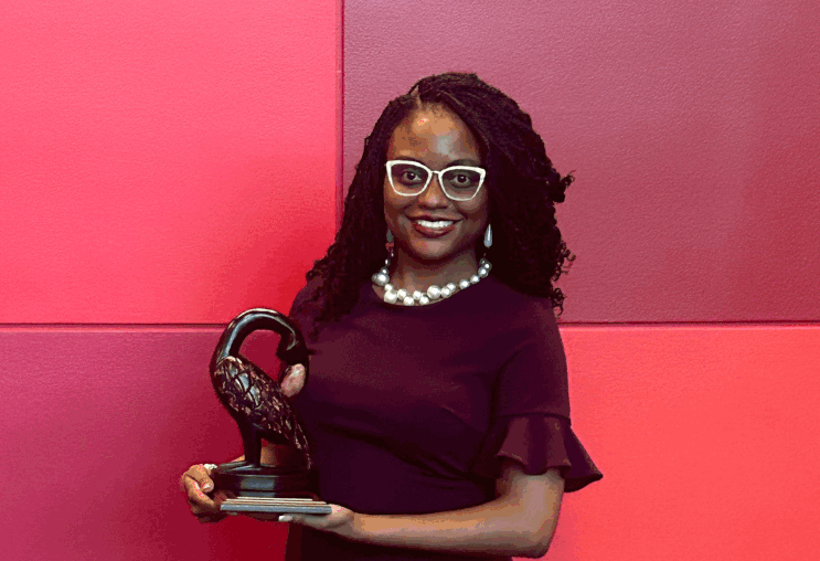 A woman holds up an award
