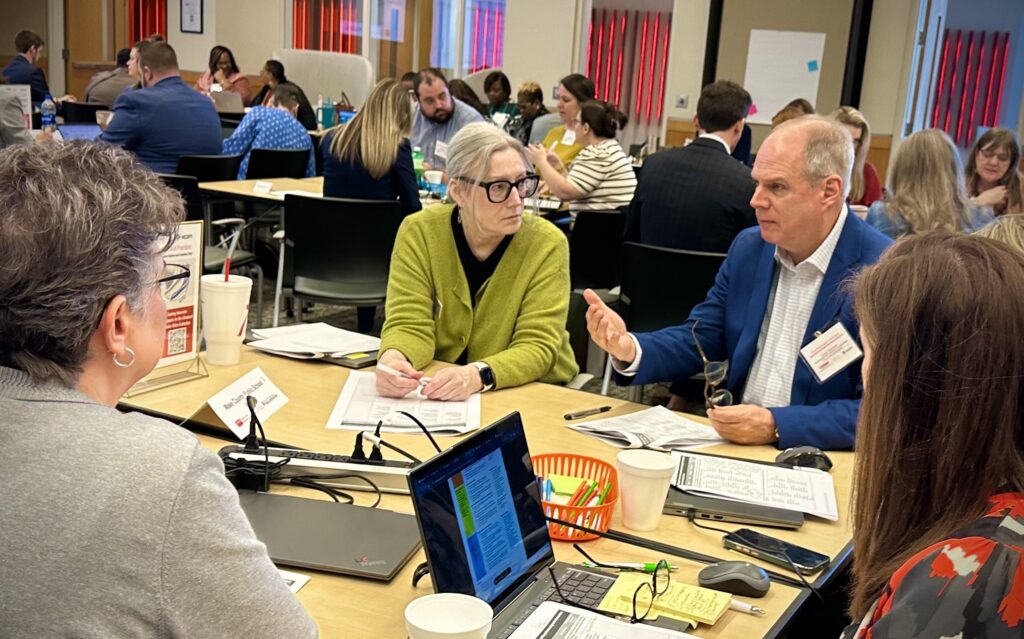 A group of educators talk around a table