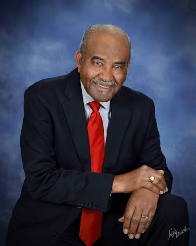 Man in a suit and red tie poses for camera