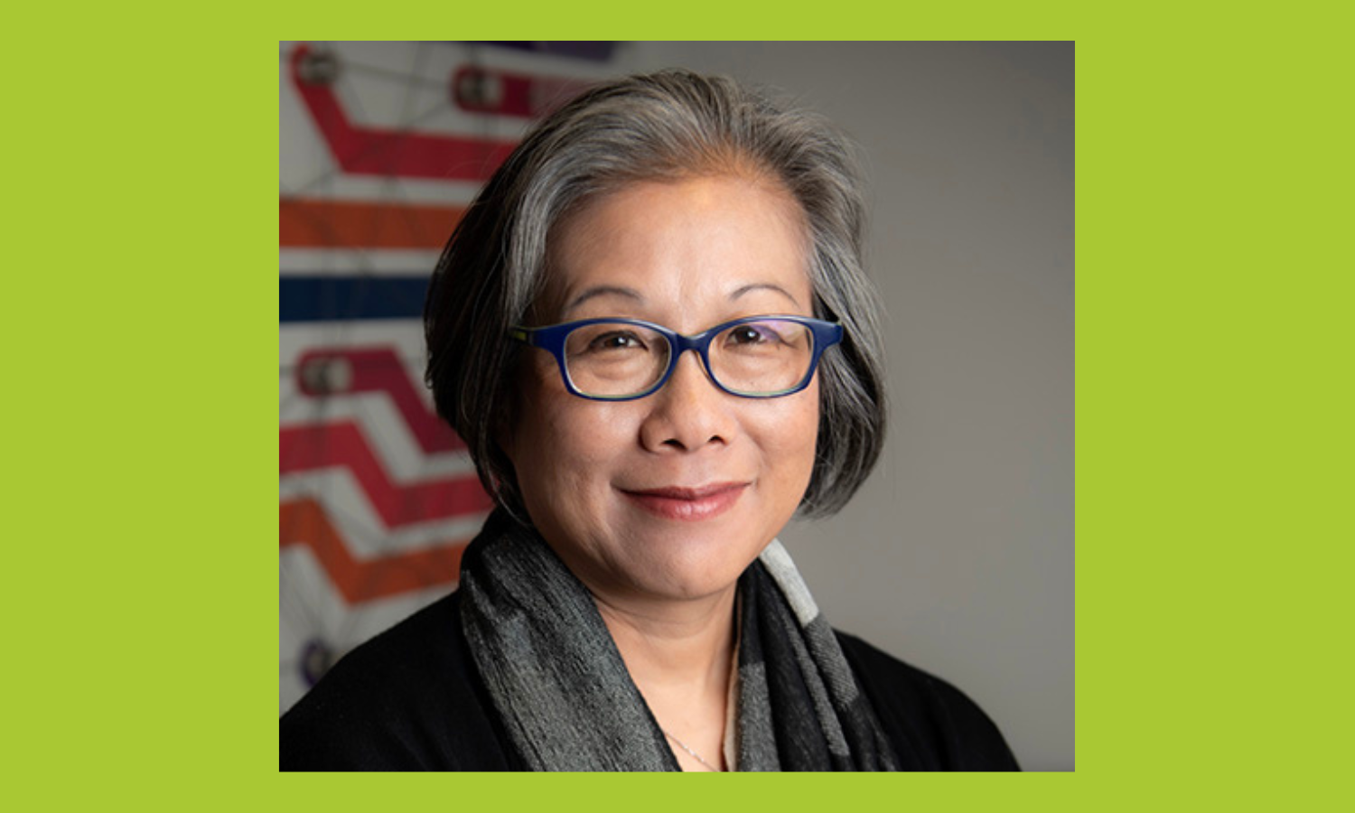 Headshot of Mimi Ito, a woman with short salt and pepper hair and a gray scarf